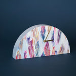 Decorative clock with colorful abstract design on a dark background